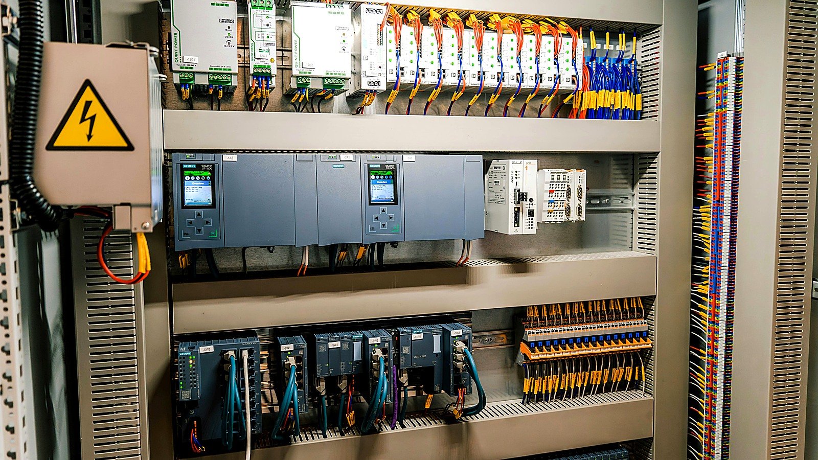 Open industrial electrical control panel with visible wiring and modules